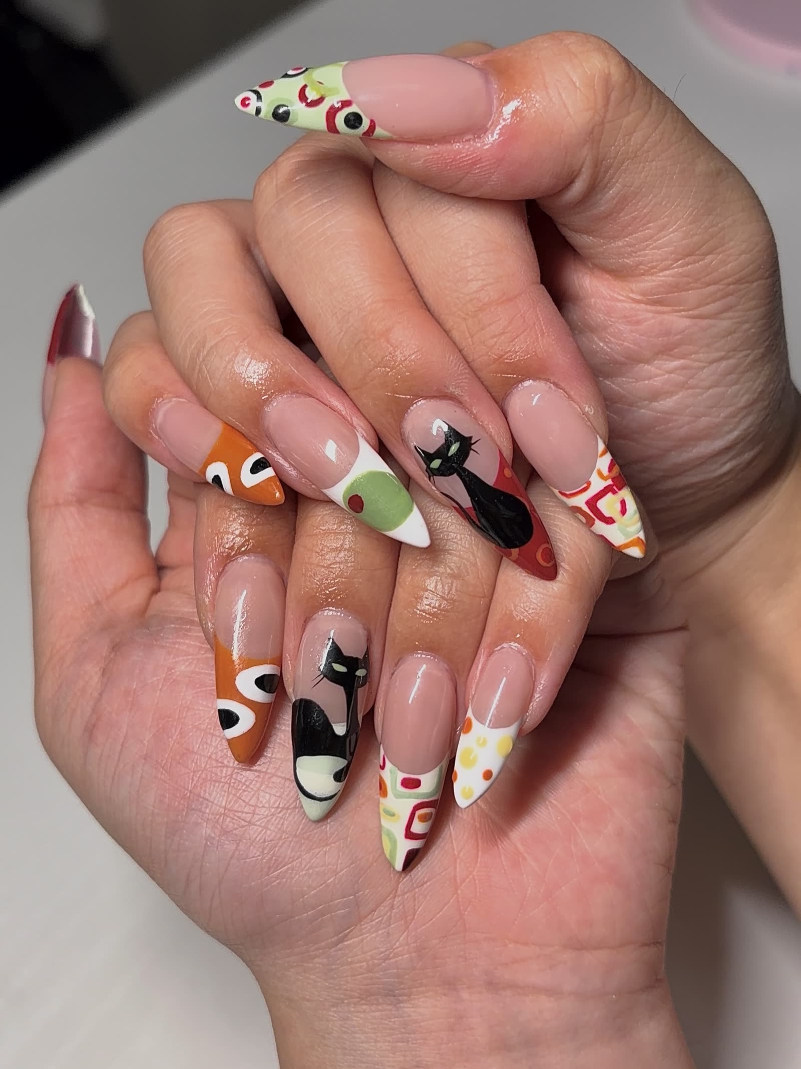 Retro mid-century art across a stiletto set — hand-painted black cats, olive circles and atomic shapes