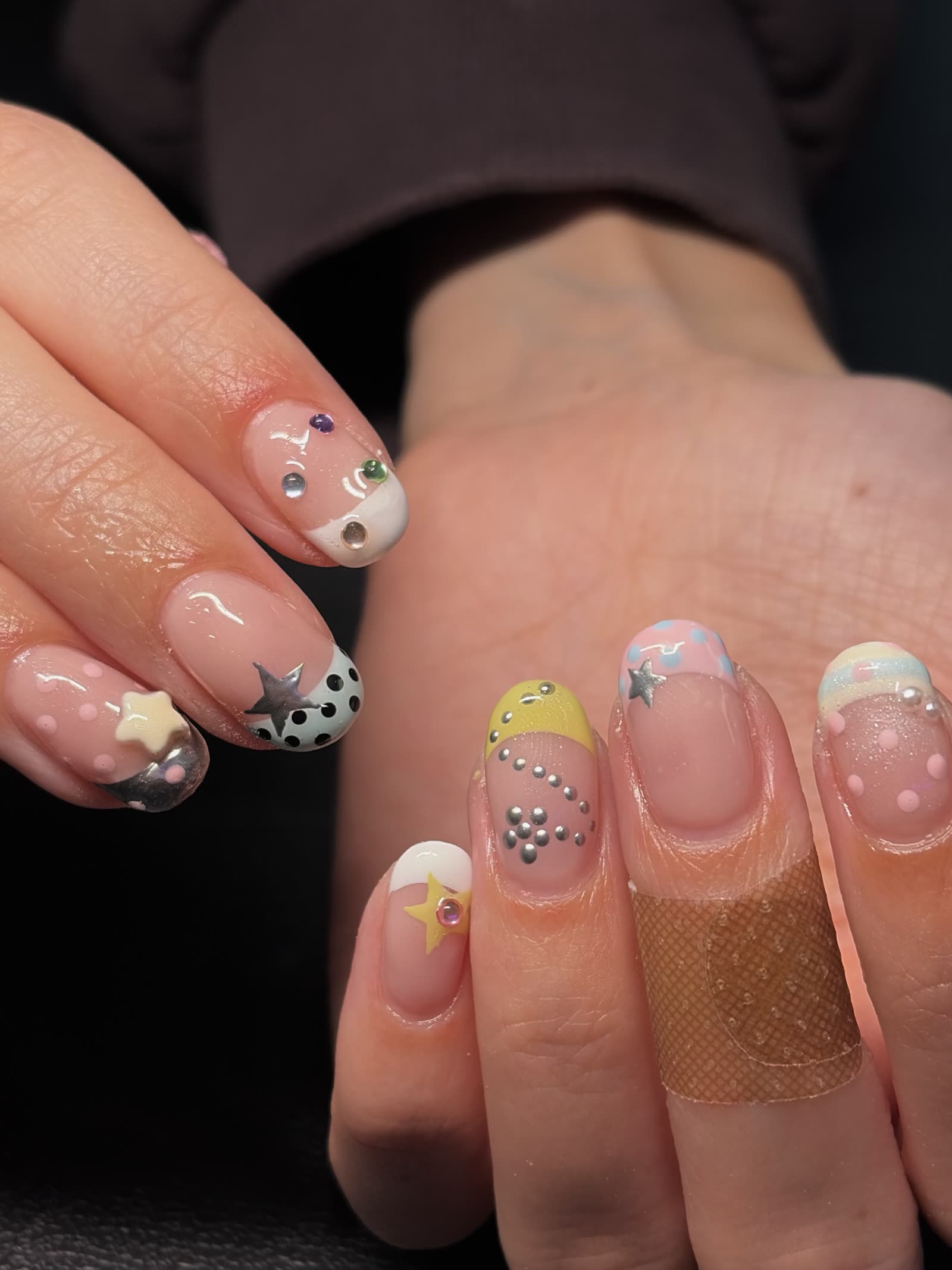Short natural nails with pastel French tips, silver stars, 3D star charms and scattered rhinestones